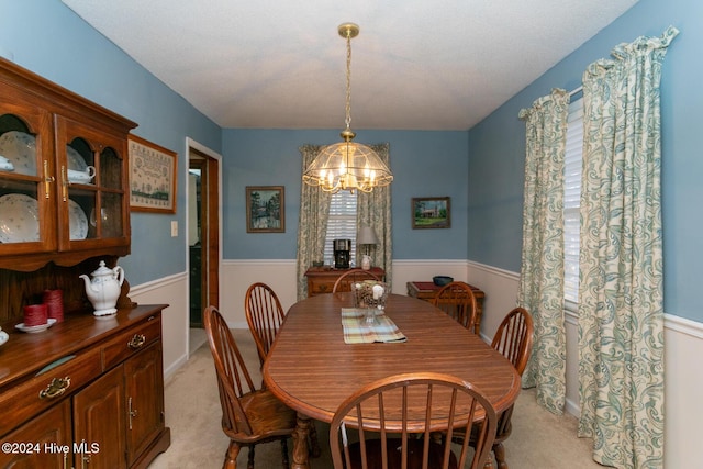 dining room with a chandelier and light colored carpet