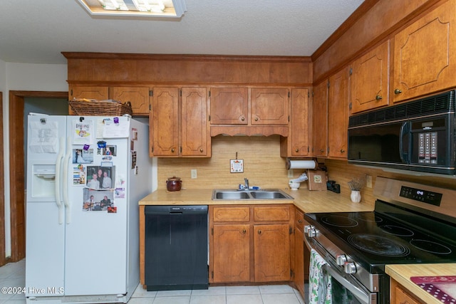 kitchen featuring decorative backsplash, a textured ceiling, sink, black appliances, and light tile patterned floors