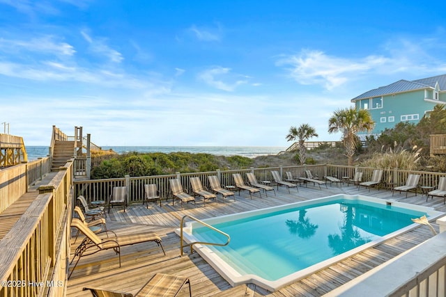 view of pool with a deck with water view