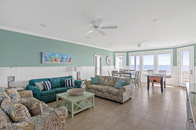 tiled living room with ornamental molding, a water view, and ceiling fan