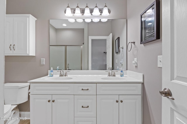 bathroom with vanity, an enclosed shower, and toilet