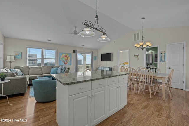 kitchen featuring a kitchen island, white cabinets, pendant lighting, and light wood-type flooring