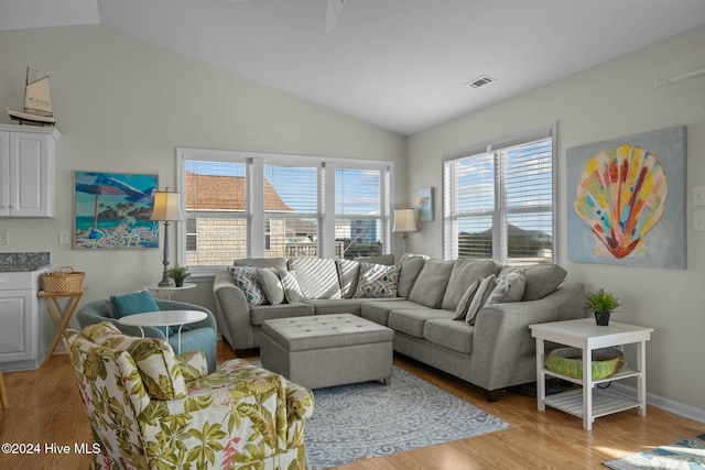 living room featuring light hardwood / wood-style flooring and vaulted ceiling