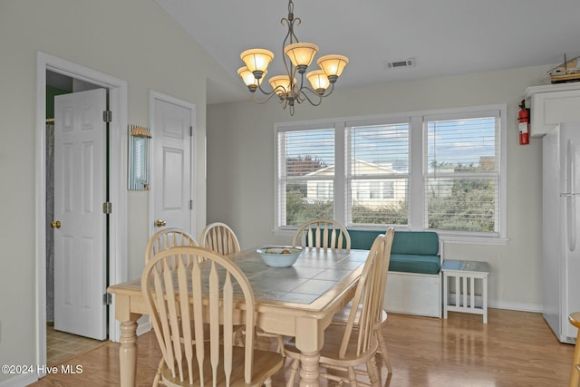 dining area with an inviting chandelier and lofted ceiling