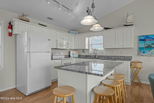 kitchen featuring white appliances, decorative light fixtures, white cabinetry, and light hardwood / wood-style floors