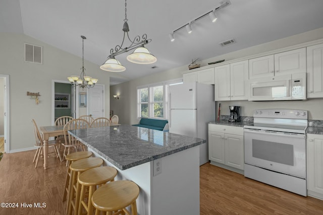 kitchen featuring a center island, white appliances, white cabinets, vaulted ceiling, and light wood-type flooring