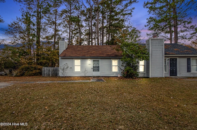 property exterior at dusk featuring a yard