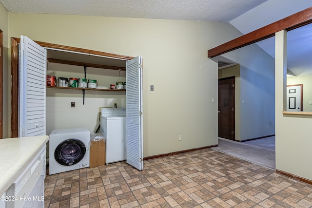 laundry room with washing machine and clothes dryer and a textured ceiling