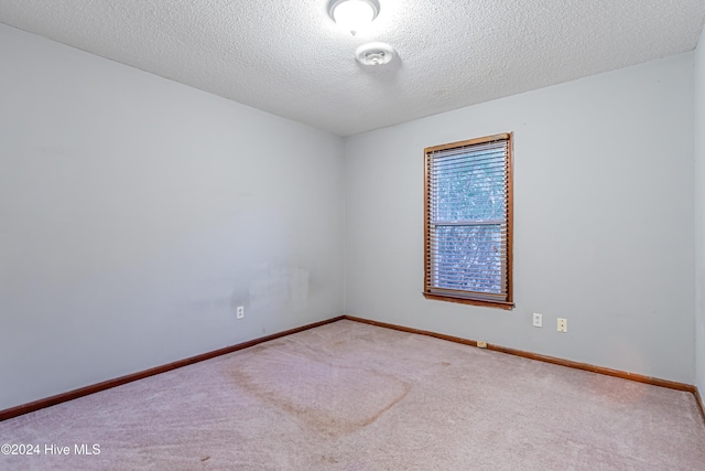 carpeted empty room with a textured ceiling