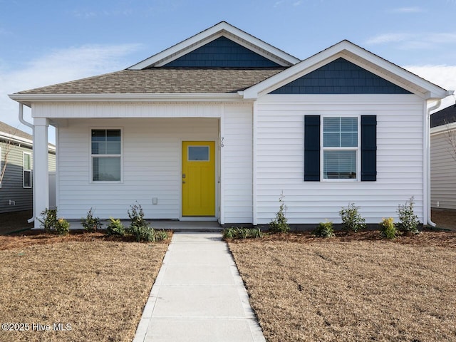 view of front of home featuring a porch, roof with shingles, and a front lawn