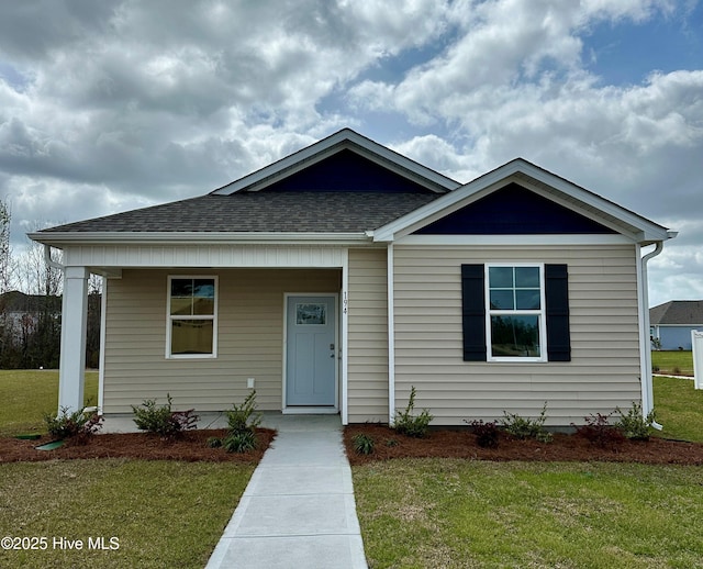 194 N Atlantic Ave Lot 128, Wilmington, NC 28411 - view of front of home featuring covered porch, roof with shingles, and a front lawn
