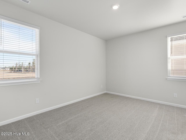 carpeted spare room featuring baseboards