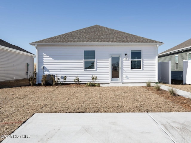 back of property with a patio and a shingled roof