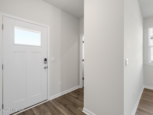 foyer featuring baseboards and wood finished floors