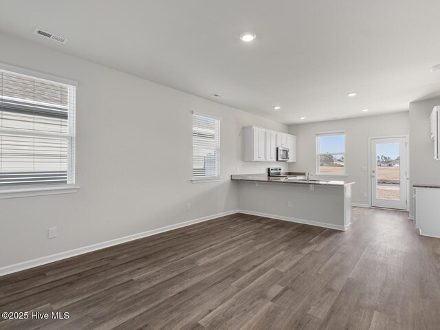 194 N Atlantic Ave Lot 128, Wilmington, NC 28411 - kitchen featuring visible vents, a peninsula, stainless steel appliances, white cabinetry, and dark wood-style floors