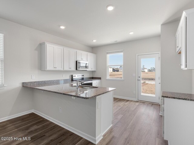 194 N Atlantic Ave Lot 128, Wilmington, NC 28411 - kitchen with dark stone countertops, dark wood-style flooring, a sink, and stainless steel appliances