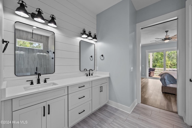 bathroom with ceiling fan, plenty of natural light, vanity, and wood walls