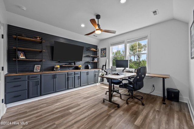 home office featuring light hardwood / wood-style flooring, vaulted ceiling, and ceiling fan