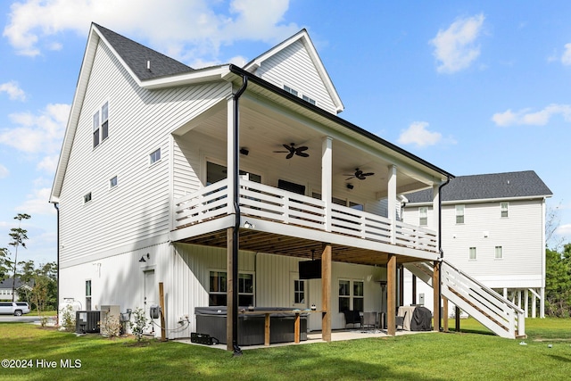 rear view of house featuring a hot tub, a yard, a deck, and a patio area