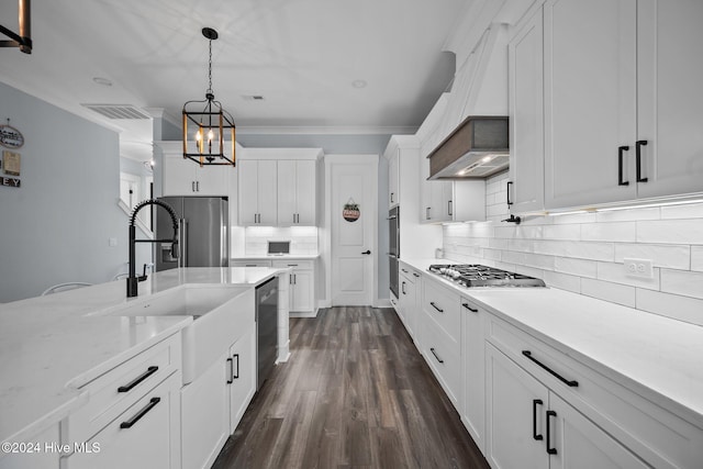 kitchen with premium range hood, white cabinetry, hanging light fixtures, an inviting chandelier, and stainless steel appliances