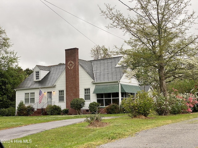 cape cod-style house featuring a front yard