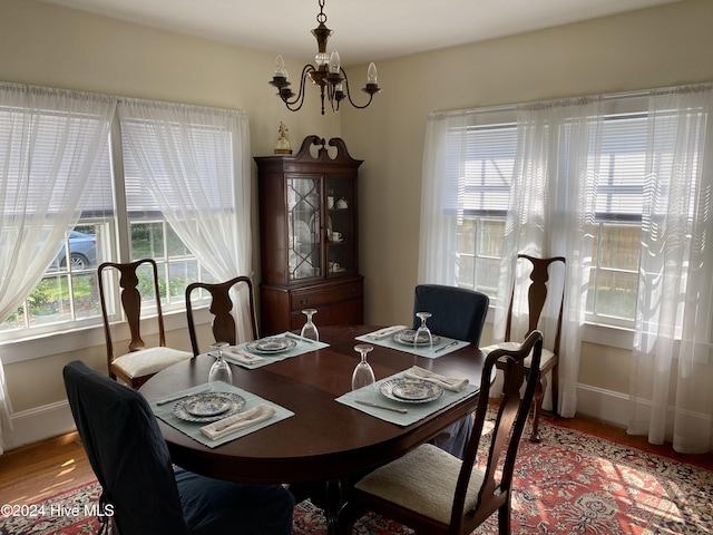 dining area featuring hardwood / wood-style flooring and an inviting chandelier