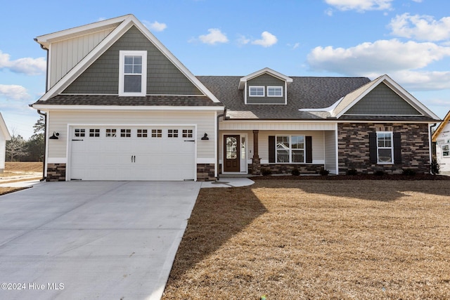 craftsman house with a porch, a garage, and a front lawn