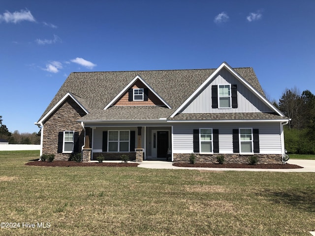 craftsman inspired home featuring covered porch and a front lawn