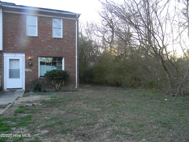 view of front of house with a front yard and brick siding