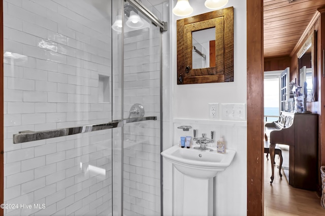 bathroom featuring wood ceiling, wood-type flooring, and a shower with shower door