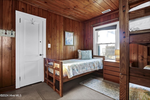 bedroom with wooden ceiling and wooden walls