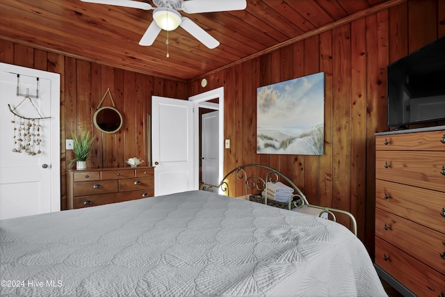 bedroom featuring wood ceiling, ceiling fan, ornamental molding, and wood walls