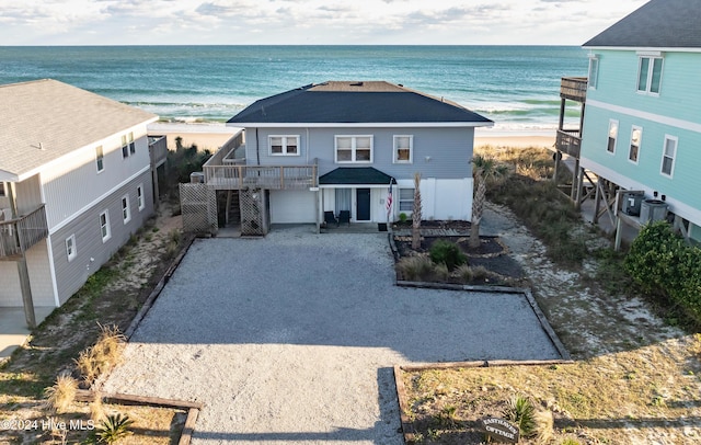 view of front of property with a water view, a beach view, and a garage