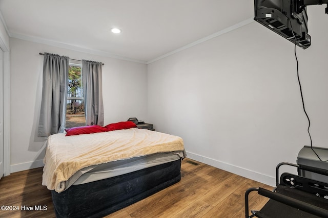 bedroom featuring wood-type flooring and ornamental molding