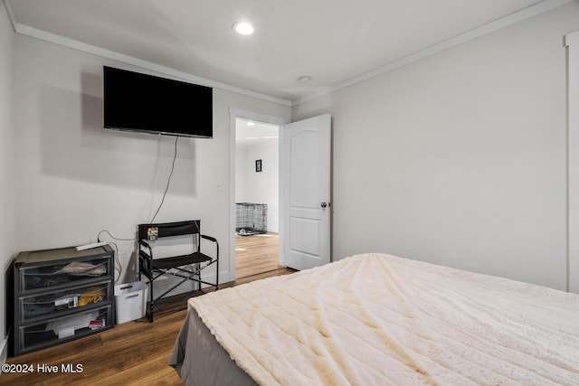 bedroom featuring hardwood / wood-style flooring and crown molding