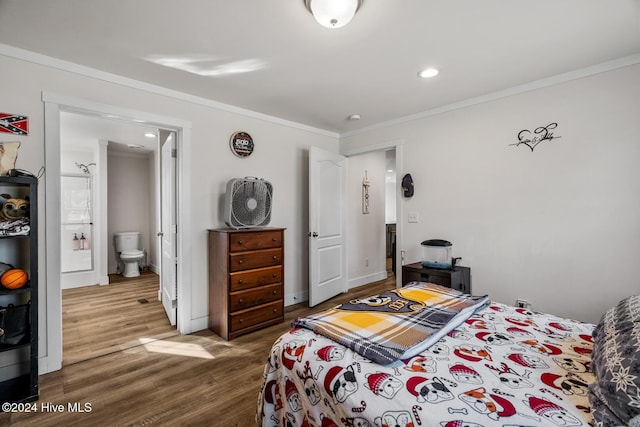 bedroom featuring hardwood / wood-style flooring, ensuite bathroom, and ornamental molding