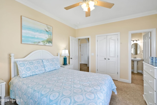 carpeted bedroom with crown molding, sink, ensuite bathroom, and a closet