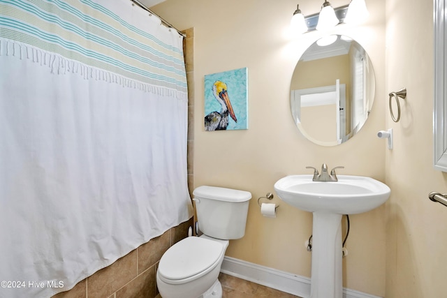 bathroom featuring sink, toilet, and a shower with shower curtain