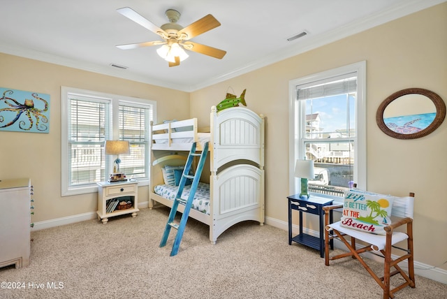 bedroom with crown molding, light colored carpet, and ceiling fan