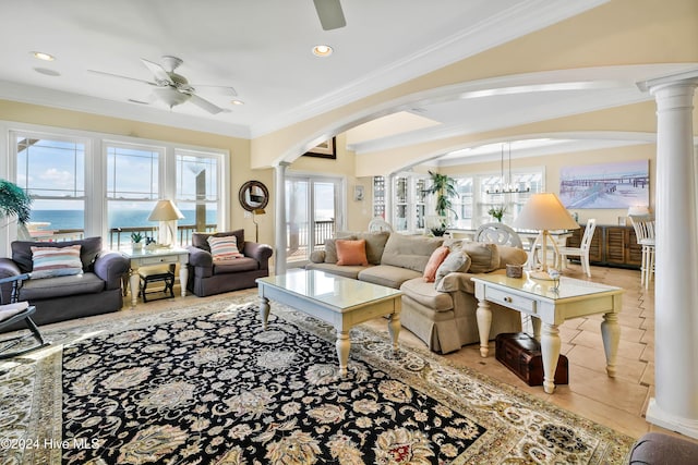 tiled living room with ornamental molding, decorative columns, ceiling fan, and a water view