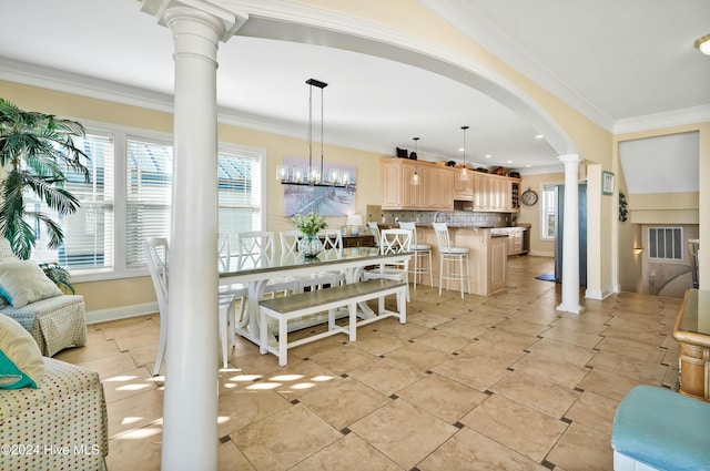 interior space featuring crown molding, a notable chandelier, and ornate columns