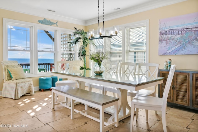 tiled dining area featuring ornamental molding, a water view, and a chandelier