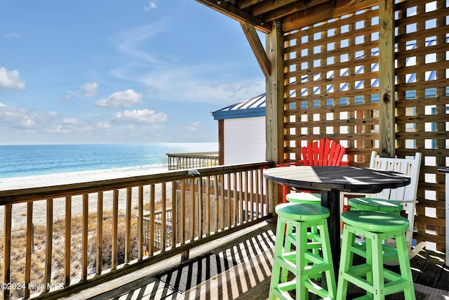 balcony with a water view and a beach view