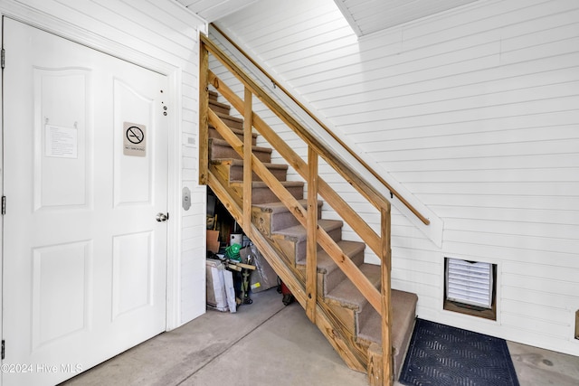 stairs with concrete floors and wooden walls