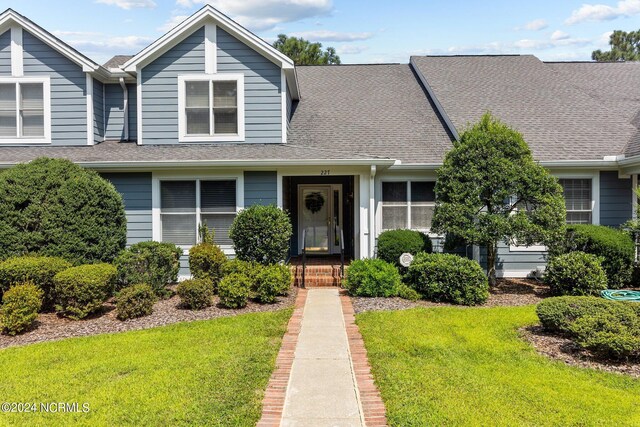 view of front of home featuring a front lawn and roof with shingles