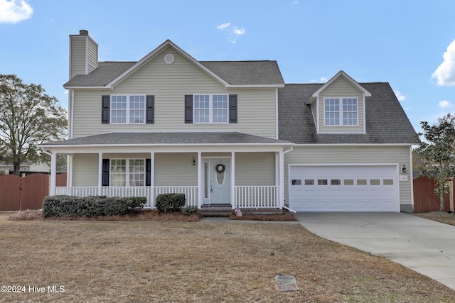 view of front property featuring a porch, a garage, and a front lawn