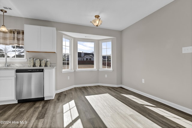 kitchen with pendant lighting, white cabinetry, stainless steel dishwasher, and a healthy amount of sunlight