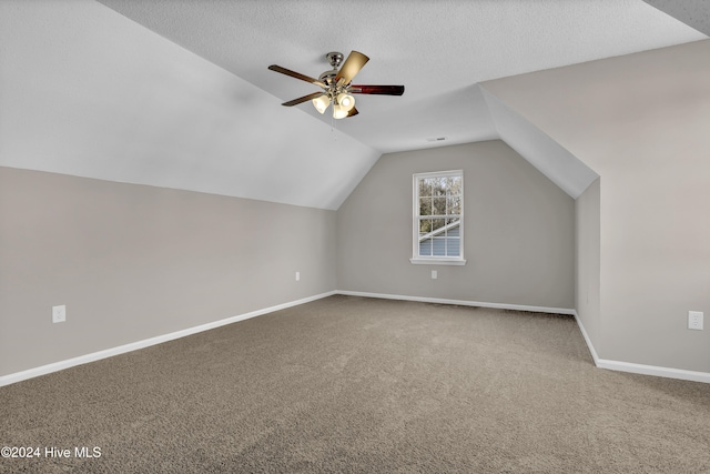 bonus room with a textured ceiling, ceiling fan, carpet flooring, and vaulted ceiling