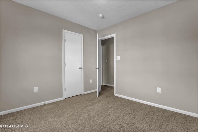 unfurnished bedroom featuring carpet flooring and a textured ceiling