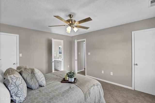 bedroom with carpet, ceiling fan, ensuite bathroom, and a textured ceiling